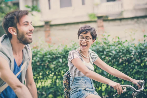 Couple d'amis jeune homme et femme à vélo — Photo