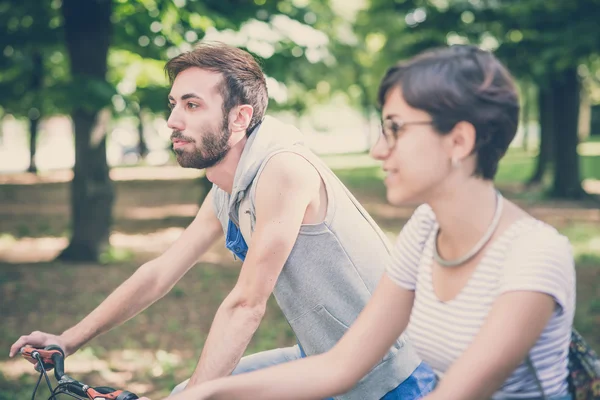 Coppia di amici giovane uomo e donna in sella alla bicicletta — Foto Stock