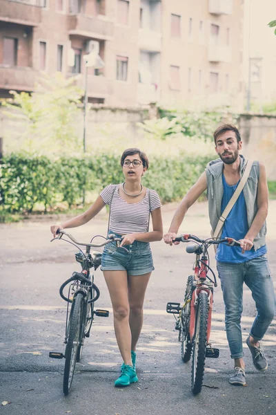 Couple of friends young  man and woman riding bike — Stock Photo, Image