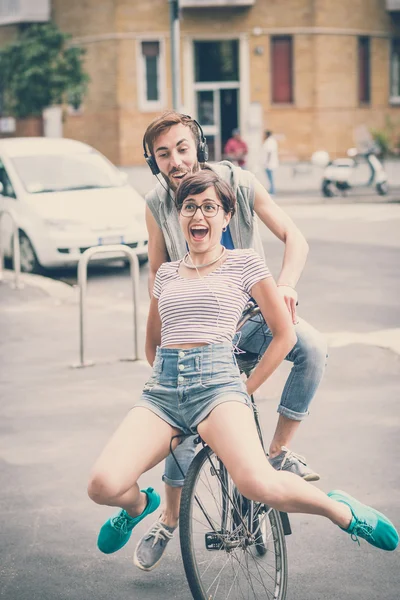 Pareja de amigos joven hombre y mujer montar en bicicleta — Foto de Stock