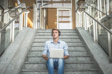 Genç model hansome sarışın adam kulaklık ve defter