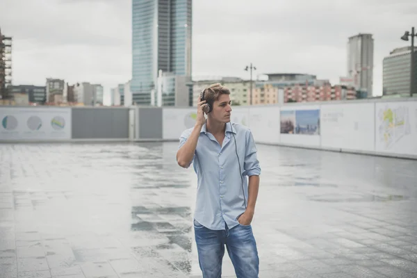 Joven modelo hansome hombre rubio con auriculares — Foto de Stock