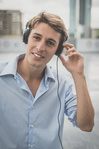 Joven modelo hansome hombre rubio con auriculares — Foto de Stock