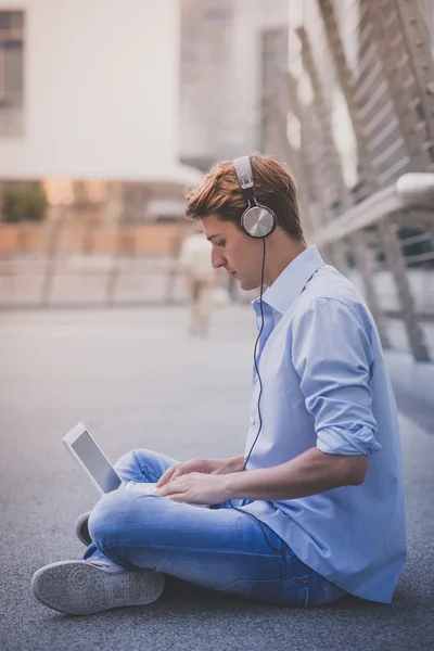 Fiatal modell hansome szőke férfi notebook és fejhallgató — Stock Fotó