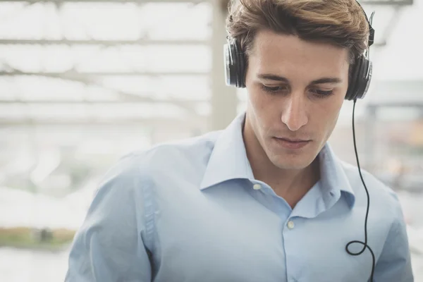 Joven modelo hansome hombre rubio con auriculares — Foto de Stock