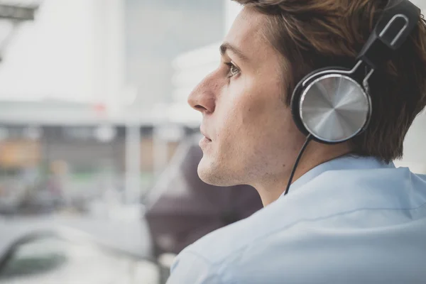 Joven modelo hansome hombre rubio con auriculares — Foto de Stock