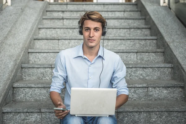 Jonge model hansome blonde man hoofdtelefoon en notebook — Stockfoto