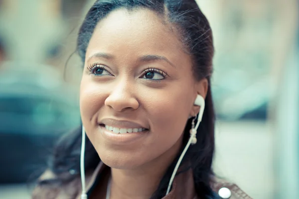 Mujer africana escuchando auriculares de música — Foto de Stock