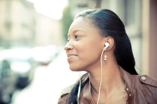 Afrikansk kvinna lyssna musik hörlurar — Stockfoto