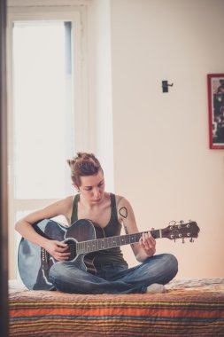 Genç lezbiyen şık saç stili kadın gitar çalmak