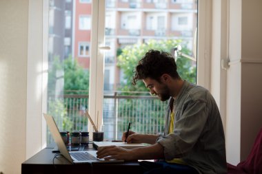 handsome hipster modern man working home using laptop clipart