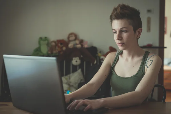 Young lesbian stylish hair style woman using notebook — Stock Photo, Image