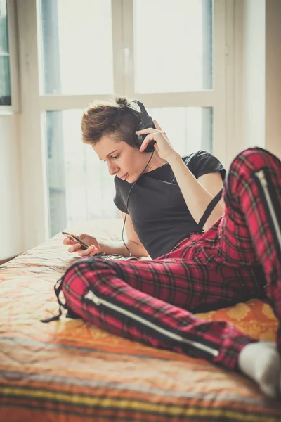 Jovem lésbica elegante cabelo estilo mulher ouvindo música — Fotografia de Stock