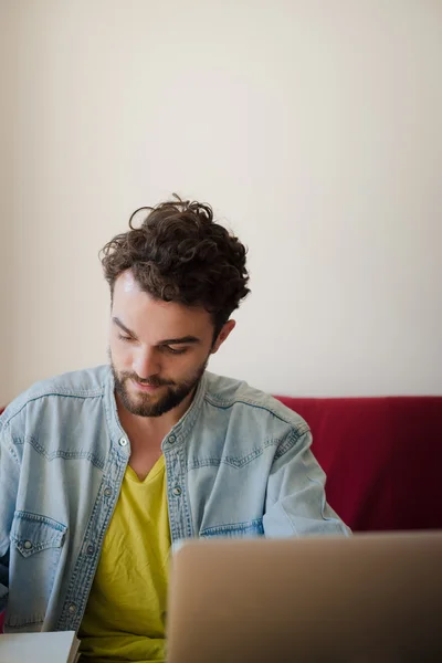 Bonito hipster moderno homem trabalhando em casa usando laptop — Fotografia de Stock