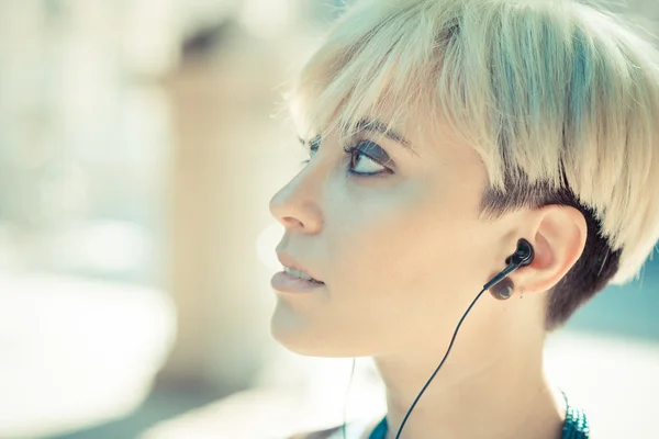 Beautiful young blonde short hair hipster woman listening music — Stock Photo, Image