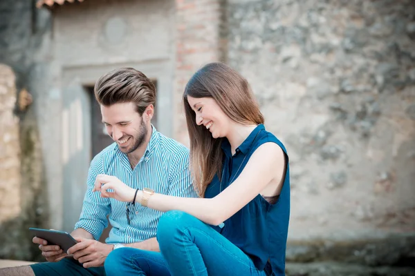 Jóvenes amantes de la pareja hermosa usando tableta — Foto de Stock