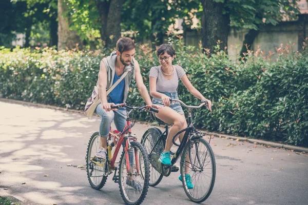 Paar van vrienden jonge man en vrouw rijden fiets — Stockfoto