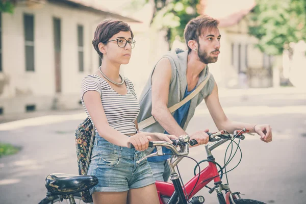 Pareja de amigos joven hombre y mujer montar en bicicleta — Foto de Stock
