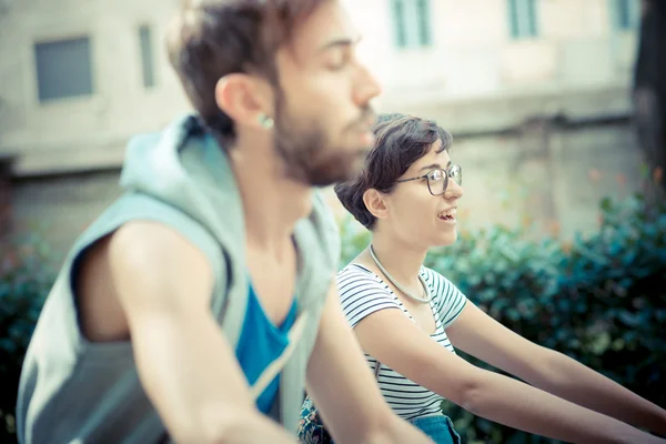 Couple of friends young  man and woman riding bike — Stock Photo, Image