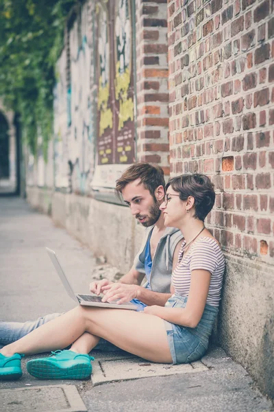 Casal de amigos jovem e mulher usando laptop — Fotografia de Stock