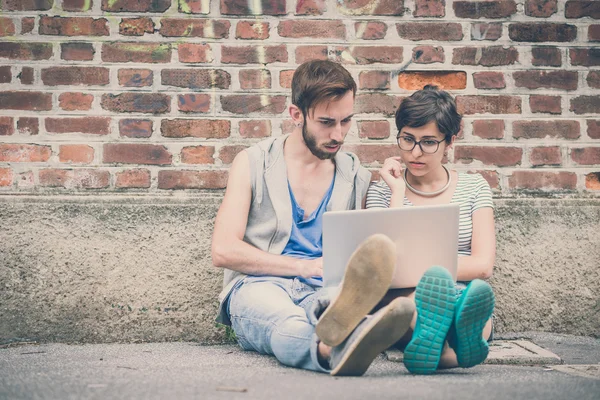 Pareja de amigos joven hombre y mujer usando el ordenador portátil — Foto de Stock