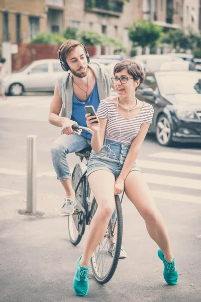 Pareja de amigos joven hombre y mujer montar en bicicleta — Foto de Stock