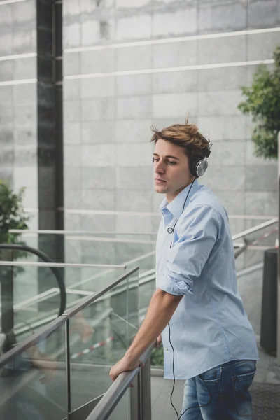 Joven modelo hansome hombre rubio con auriculares — Foto de Stock