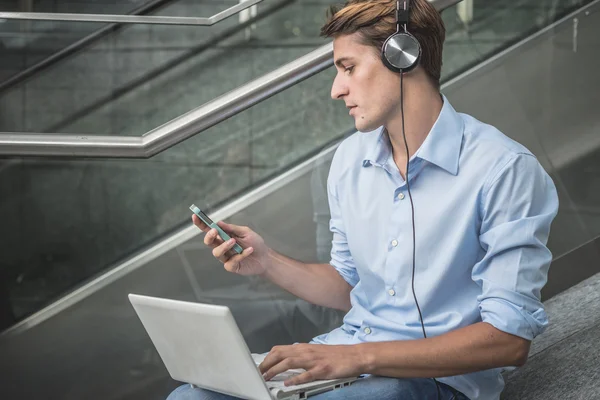 Junges Modell hansome blonde Mann Kopfhörer und Notizbuch — Stockfoto