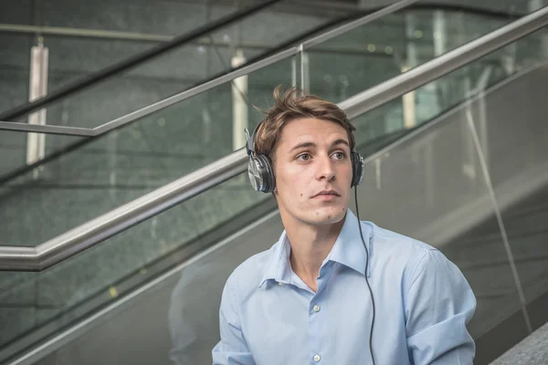 Joven modelo hansome rubia hombre auriculares y portátil —  Fotos de Stock