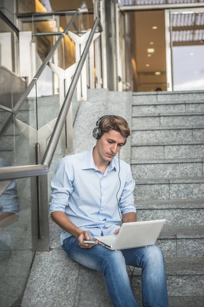 Jonge model hansome blonde man hoofdtelefoon en notebook — Stockfoto