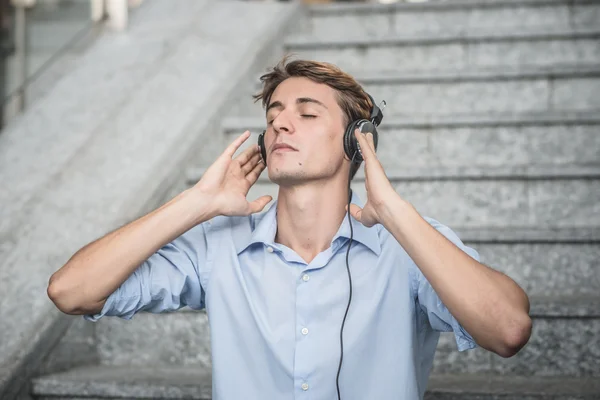 Joven modelo hansome hombre rubio con auriculares — Foto de Stock