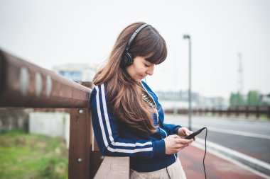 akıllı telefon kullanan ve müzik dinlemek güzel bir kadın