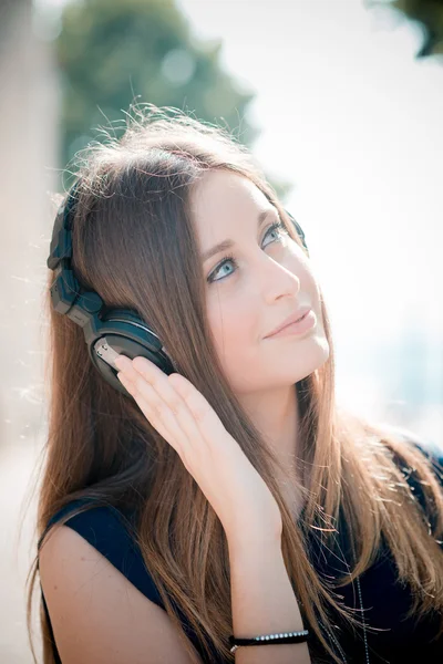 Joven hermosa mujer hipster escuchando música con auriculares — Foto de Stock