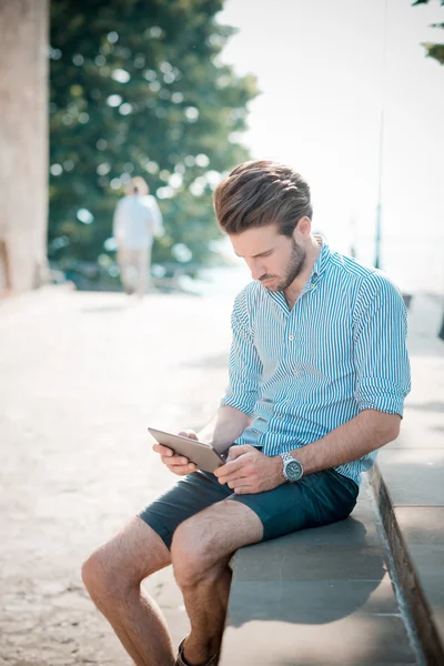 Mladý pohledný bederní moderního člověka venkovní použití tabletu — Stock fotografie