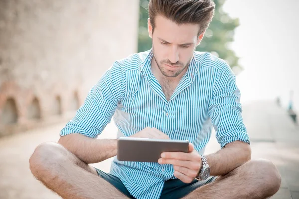 Jonge knappe hipster moderne mens buiten met behulp van Tablet PC — Stockfoto