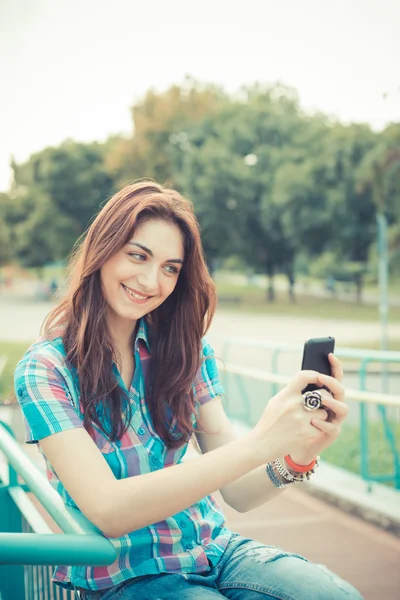 Hermosa joven hipster mujer usando teléfono inteligente — Foto de Stock