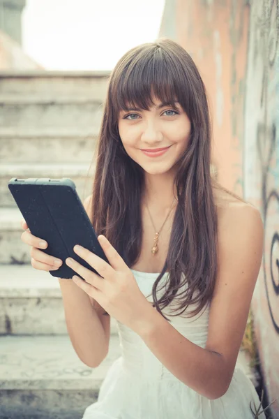 Hermosa mujer joven con vestido blanco usando tableta — Foto de Stock