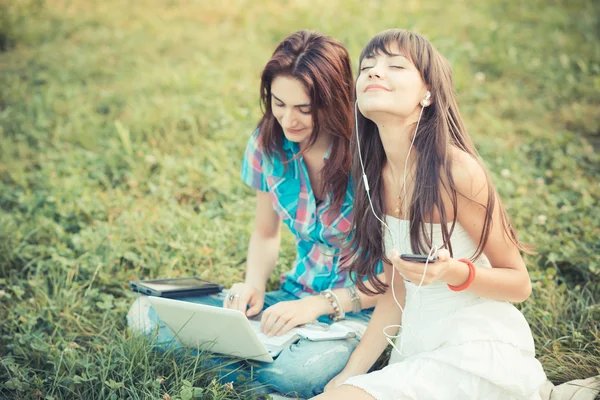 Beautiful hipster young women sisters friends using tablet and s — Stock Photo, Image