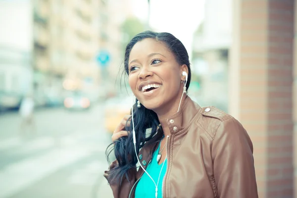 Hermosa mujer joven africana escuchando auriculares de música — Foto de Stock