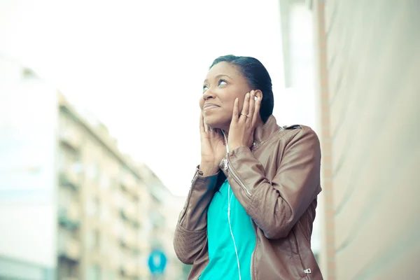 Beautiful african young woman listening music earphones — Stock Photo, Image