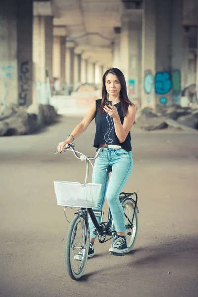 年轻美丽的黑发直头发女人使用自行车和 smar — 图库照片