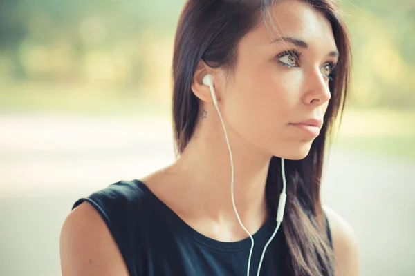 Young beautiful brunette straight hair woman listening music — Stock Photo, Image