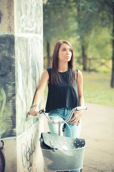 Jovem bela morena cabelo liso mulher usando bicicleta — Fotografia de Stock