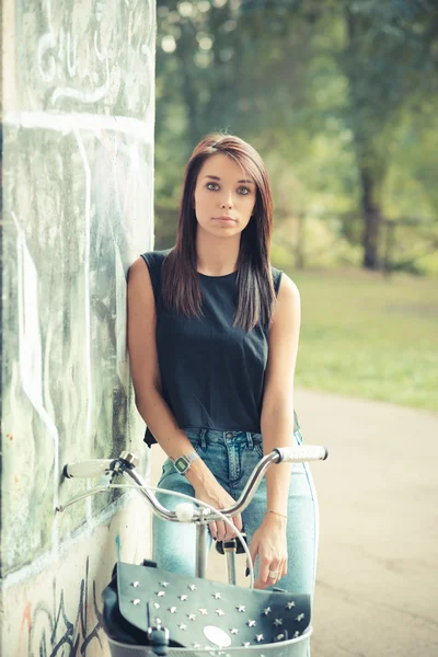 Bisiklet kullanan genç güzel esmer düz saçlı kadın — Stok fotoğraf