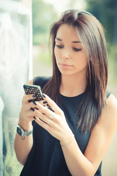 Jonge mooie brunette rechte haren vrouw met behulp van smartphone — Stockfoto