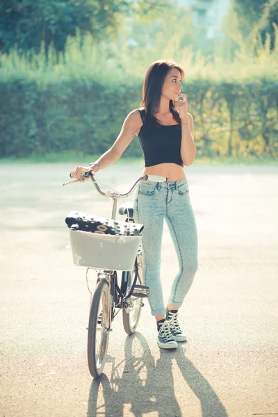 自転車を使用して若い美しいブルネット ストレートの髪の女性 — ストック写真