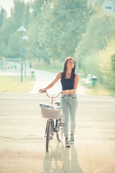 Joven hermosa morena pelo liso mujer usando bicicleta — Foto de Stock