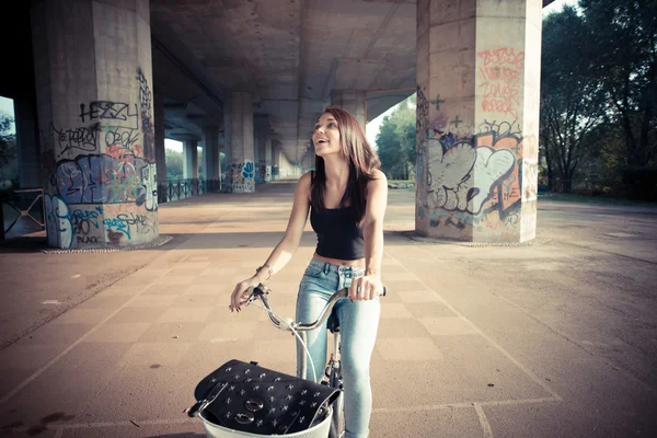 Νέοι όμορφη μελαχρινή με ίσια μαλλιά γυναίκα χρησιμοποιώντας ποδήλατο — Φωτογραφία Αρχείου