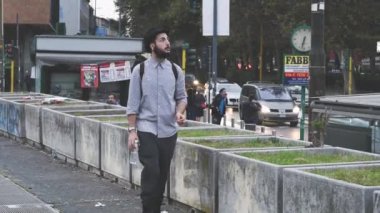Şehirde yürüyen hipster adam