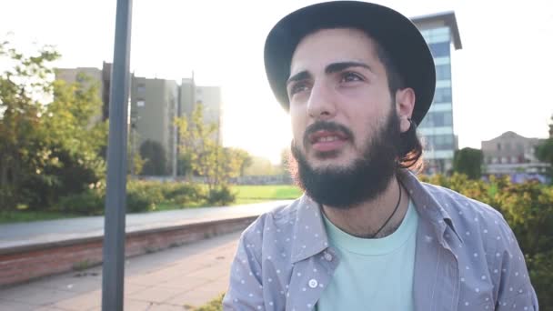 Бородатий чоловік палить у місті — стокове відео